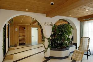 a hallway with arches and plants in a building at Hotel Lasalt in Ischgl