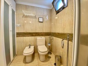 a bathroom with a toilet and a shower and a television at Apartamento beach house in Las Palmas de Gran Canaria +14 photos