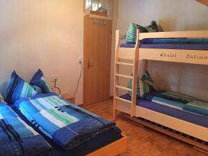 a room with two bunk beds and a ladder at Chalet Julian in Lütschental