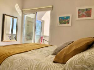 a bedroom with a large bed with a window at Pequeño paraíso frente al mar Playa Chica in Santa Cruz de Tenerife
