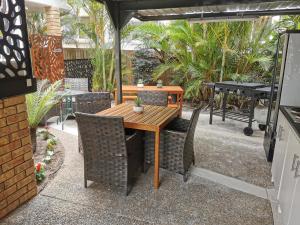 a wooden table and chairs under an umbrella at Limassol Motel in Gold Coast