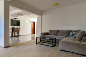 a living room with a couch and a glass coffee table at Apartmani Djurovic in Ulcinj