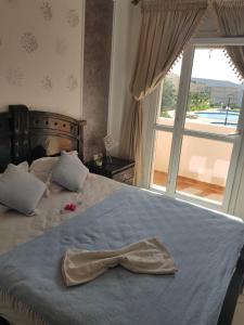 a bedroom with a bed with a bow tie on it at FamilyConfort Saidia in Saïdia