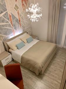 a bedroom with a large bed and a chandelier at B&B Nearby Malpensa in Samarate