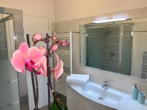 a bathroom with a sink and a pink flower at B&B Nearby Malpensa in Samarate