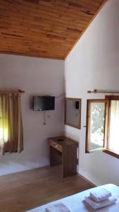 a bedroom with a desk and a tv on the wall at Armina Pension in Cıralı