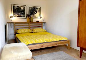 a bedroom with a bed with a yellow comforter at Das Haus am Berg in Rathmannsdorf