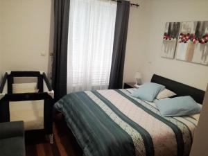 um quarto com uma cama com almofadas azuis e uma janela em Uptown Madalenas em Funchal