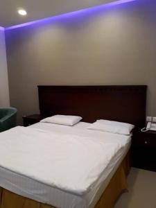a bed with two white pillows on top of it at White Beach Hotel Suites in Rabigh