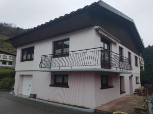 ein weißes Gebäude mit einem Balkon an der Seite in der Unterkunft La Pinéguette maison 12 personnes spa 6 pers décoration chalet sauna 4 pers in La Bresse