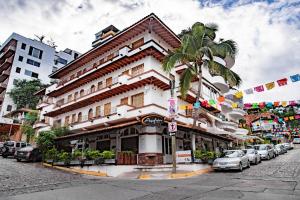 巴亚尔塔港奥拉斯艾塔斯套房公寓酒店的街道前有棕榈树的建筑