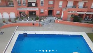 a large swimming pool in front of a building at Rinconcito Roteńo in Rota +5 photos