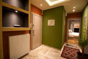 um corredor com paredes verdes, uma porta e um quarto em Eros - Luxurious Apartment em Tessalônica
