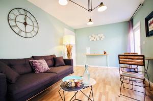 uma sala de estar com um sofá e um relógio na parede em #Private Scandinave Sweet House ! em Saint-Dizier