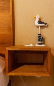 un estante de madera con un pájaro de juguete. en Olas Altas Suites Departamentos en Puerto Vallarta
