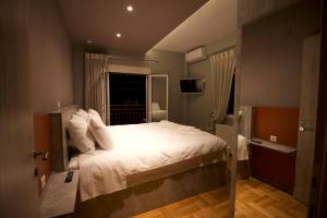 sypialnia z dużym białym łóżkiem i oknem w obiekcie Eros - Luxurious Apartment w Salonikach