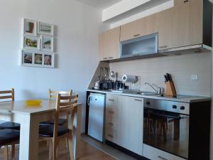 F307 Studio Aspen Golf Resort Bansko في بانسكو: مطبخ مع طاولة ومغسلة وموقد