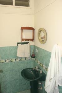 Baño verde con lavabo y espejo en CAMBULOS, en Cali