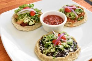 three small pizzas on a white plate with salsa at Tlaquepaque Pueblito in Guadalajara