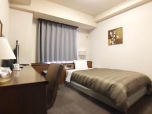 Habitación de hotel con cama y escritorio en HOTEL ROUTE-INN Ueda - Route 18 -, en Ueda
