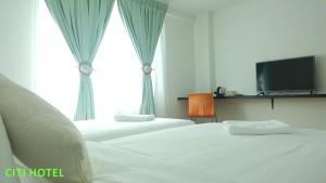 Llit o llits en una habitació de Citi Hotel