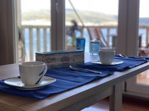 a table with two coffee cups and a box on it at Casa Mar y Sol in Corcubión