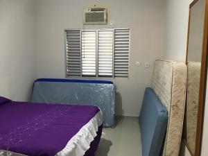 una camera con un letto e una finestra con condizionatore d'aria di Mar azul Enseada a Guarujá