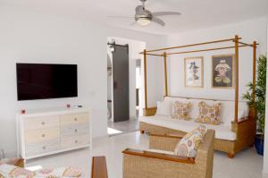 a living room with a couch and a flat screen tv at Villa Tranquilidad with amazing private terrace and heated pool in Charco del Palo