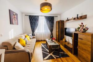sala de estar con sofá y TV en Relax Apartment 1, en Sighişoara