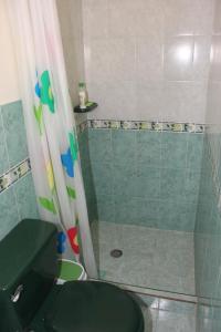 a bathroom with a shower with a toilet and a shower curtain at cambulos 2 in Cali +6 photos