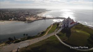 a lighthouse on a hill next to the ocean at Apartamento frente ao mar in Saquarema