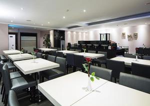 a dining room with white tables and chairs at MILORD BOUTIQUE HOTEL in Kaohsiung