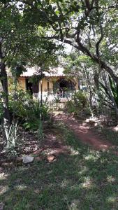 a house in the middle of a yard with trees at Pousada Casa do Arco in Santana do Riacho