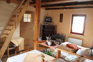 a living room with a wooden staircase and a table at Marko Apartmány in Oščadnica