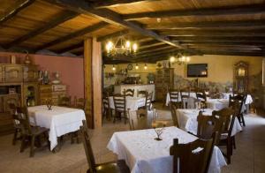 um restaurante com mesas e cadeiras brancas e uma sala com mesas e cadeiras em O Lar da Avoa em Cambados