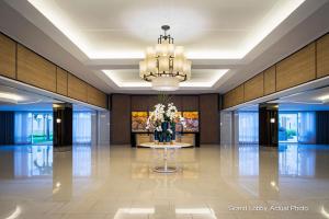 a lobby with a table and a chandelier at Shell Residences in Manila