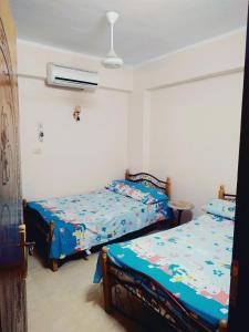 a bedroom with two beds and a air conditioner at شمس أسوان شقة شعبية رخيصة أمان in Aswan