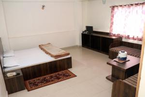 Zimmer mit 2 Etagenbetten und einem Schreibtisch in der Unterkunft Jain Residency in Pachmarhi