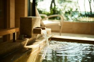 una fontana in una piscina in una casa di THE HIRAMATSU HOTELS & RESORTS KASHIKOJIMA a Shima