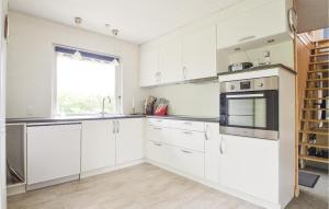 a white kitchen with white cabinets and a window at Fjordens Perle in Farsø