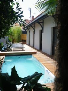 a swimming pool in the backyard of a house at La Villa Sanson in Arcachon