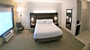 a hotel room with a bed and a flat screen tv at Holiday Inn Express & Suites Hood River by IHG in Hood River