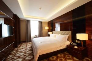LOTTE City Hotels Tashkent Palace tesisinde bir odada yatak veya yataklar