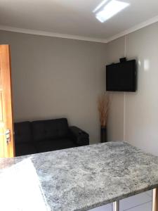 uma sala de estar com uma mesa e um sofá em Tuna Self Catering em Swakopmund