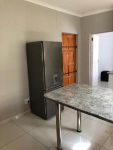a kitchen with a table and a refrigerator at Tuna Self Catering in Swakopmund