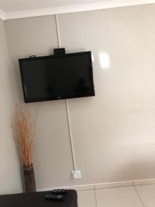 TV de pantalla plana colgada en la pared en Tuna Self Catering en Swakopmund
