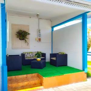 a living room with blue furniture and a green floor at Le Cascavelle in Cilaos