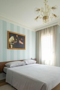 um quarto com uma grande cama branca e um lustre em Little House em Campo San Martino