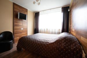 a bedroom with a bed and a window and a chair at Silvana in Vilnius