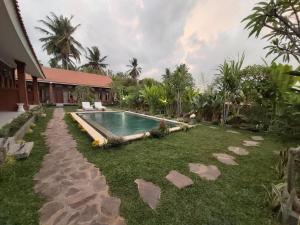 a backyard with a swimming pool and a house at Ayuna Family Ubud in Ubud